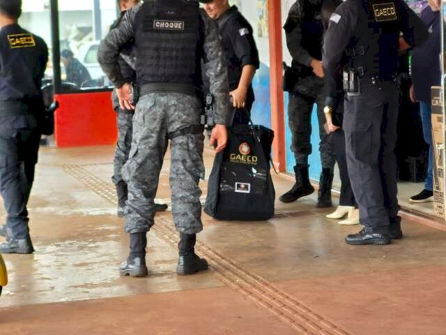 Policiais saindo com malote de uma das lojas em Sidrolândia (Foto: Marcos Maluf)
