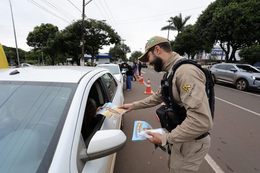 A Prefeitura de Dourados, por meio da Agetran (Agência Municipal de Transporte e Trânsito), realizou nesta sexta-feira (15) mais uma ação da campanha Maio Amarelo 2026. A blitz educativa aconteceu na Avenida Marcelino Pires, em frente ao terminal rodoviário, em parceria com o Detran-MS. Durante a mobilização, equipes abordaram motoristas, motociclistas e usuários de motos elétricas que trafegavam pela principal avenida da cidade. Além das orientações sobre direção segura e respeito às leis de trânsito, foram distribuídos panfletos educativos e repelentes contra o mosquito Aedes aegypti. A iniciativa integra a programação do Maio Amarelo, que neste ano traz o tema “No trânsito, enxergar o outro é salvar vidas”. A campanha busca conscientizar a população sobre a importância da empatia, atenção e responsabilidade coletiva para reduzir acidentes e preservar vidas. A diretora-presidente da Agetran, Rosana Fátima Ramos Gonçalves, destacou que o trânsito exige cuidado permanente de todos os envolvidos. “O trânsito impacta diretamente na vida das pessoas e exige atenção constante. Direção defensiva, respeito às normas e cuidado com o outro são fundamentais”, afirmou. Rosana ressaltou ainda que a campanha deste ano dá atenção especial aos motociclistas e aos usuários de veículos autopropelidos, como motos elétricas com velocidade de até 32 km/h. “A proposta é reforçar que atitudes simples, como reduzir a velocidade, respeitar a sinalização, dar preferência ao pedestre e evitar distrações ao volante, contribuem diretamente para preservar vidas”, enfatizou. A programação do Maio Amarelo segue até o fim do mês com diversas atividades em Dourados, incluindo palestras, novas blitzes educativas, adesivagem de motocicletas, ações em escolas e universidades, além do 2º Passeio Ciclístico da UFGD e uma campanha de doação de sangue voltada especialmente à conscientização dos motociclistas. Entre as próximas ações previstas estão blitz educativa na Rua Cuiabá, na próxima segunda-feira (18), palestra sobre saúde mental para agentes de trânsito, mobilização na BR-163 com a PRF e atividades educativas voltadas a crianças e universitários.